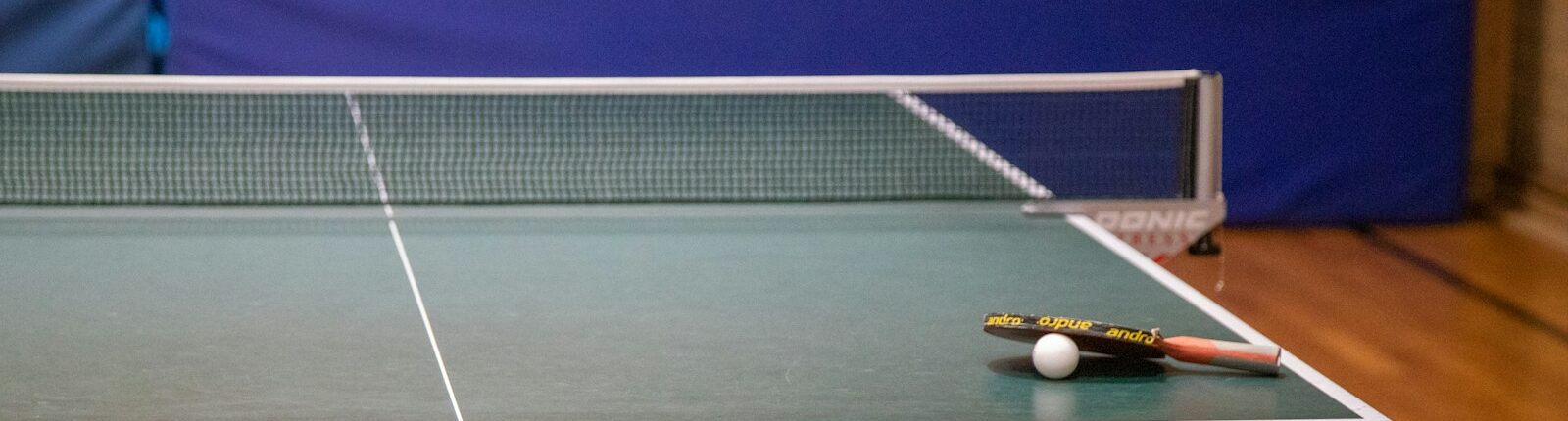 a ping pong table with a racket and ball on it